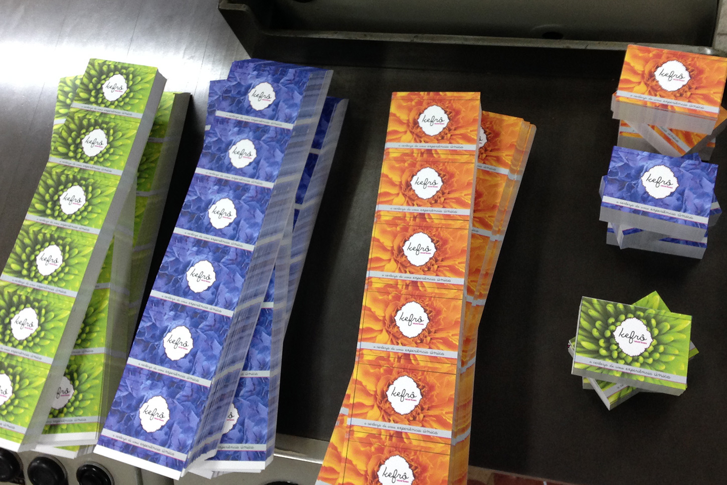 Folhas impressas com trabalhos gráficos em verde, azul e laranja